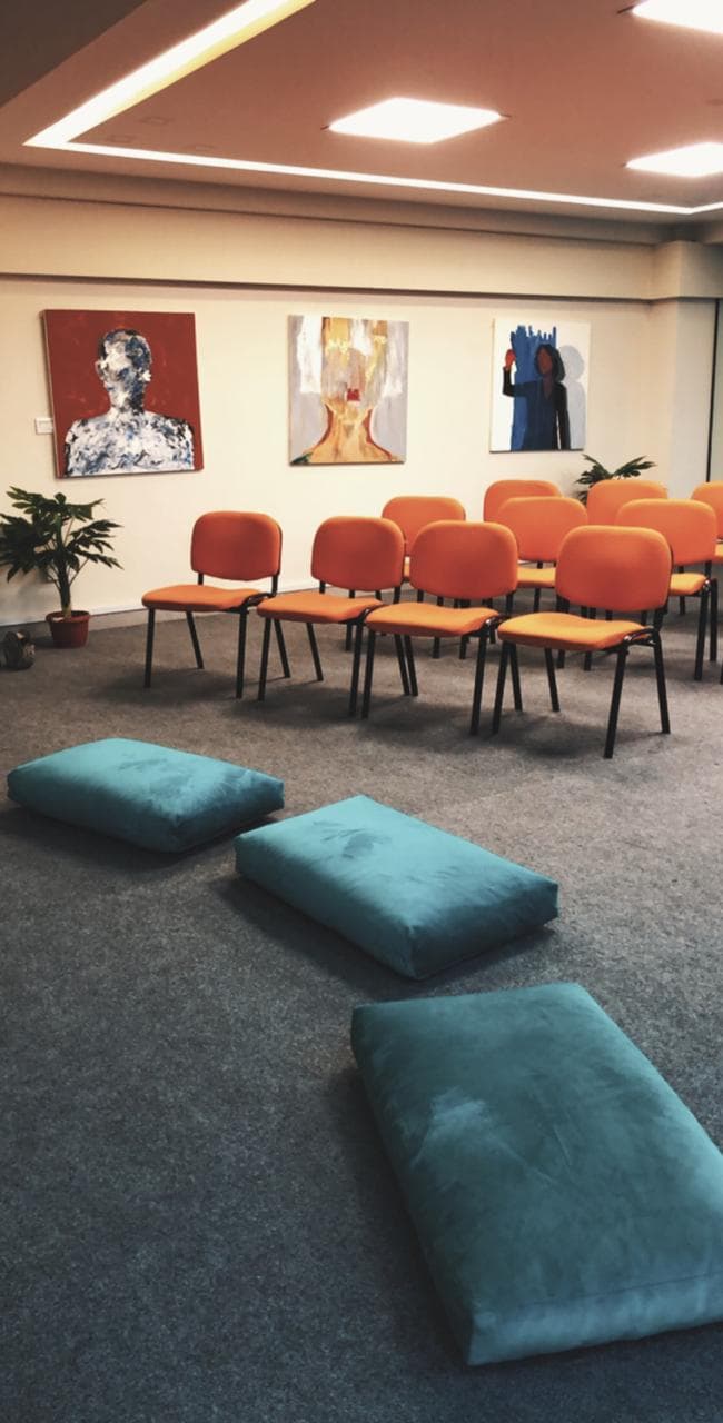 Therapy session room with chairs and floor cushions